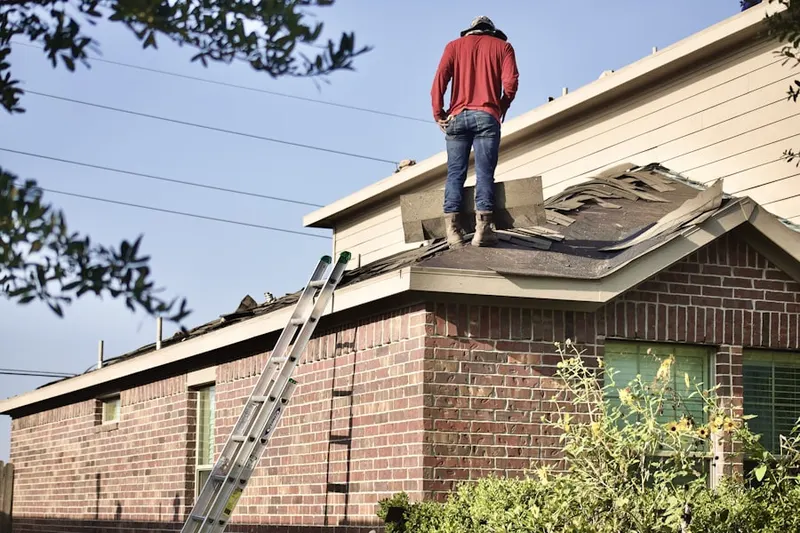 Professional roofer working on a residential roof in Hunters Creek